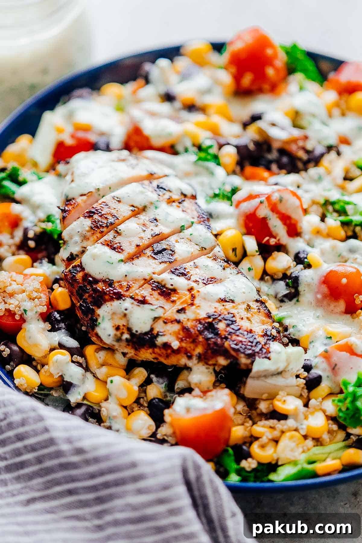 Light & Lively: 14 Summer Salads That Satisfy Without the Slump 3 A close-up view of Southwest Chicken Quinoa Bean Salad with a drizzle of creamy dressing, highlighting the vibrant ingredients.
