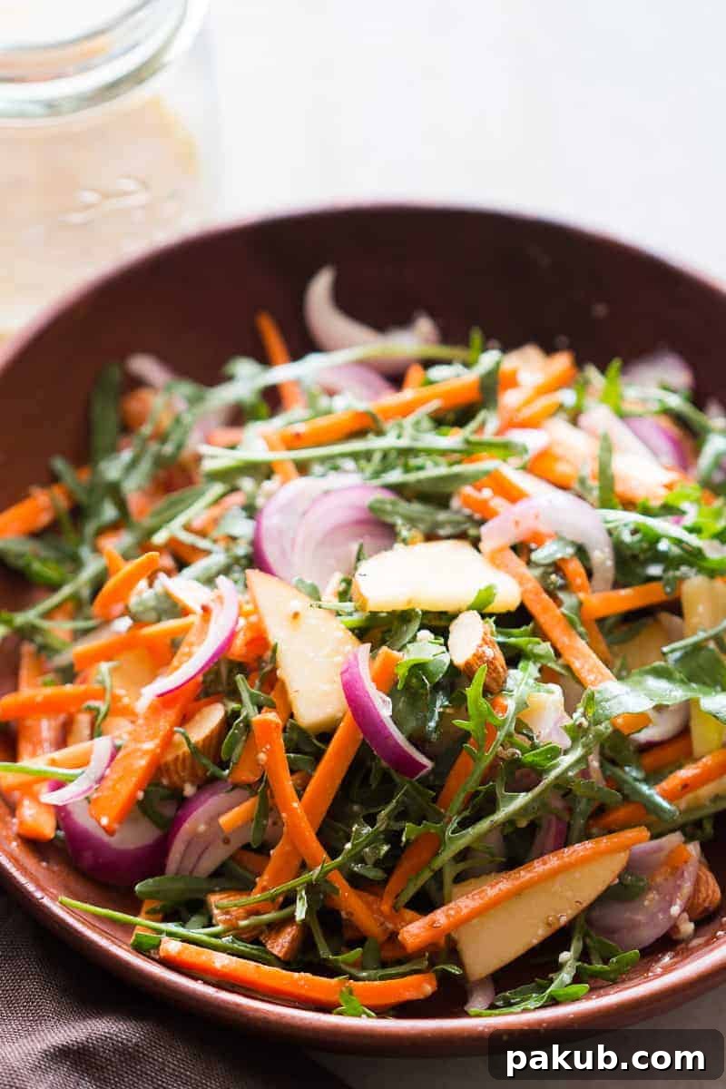 Light & Lively: 14 Summer Salads That Satisfy Without the Slump 10 A fresh Apple Arugula Almond Salad with a zesty orange marmalade dressing, showcasing vibrant greens, crisp apples, and crunchy almonds.
