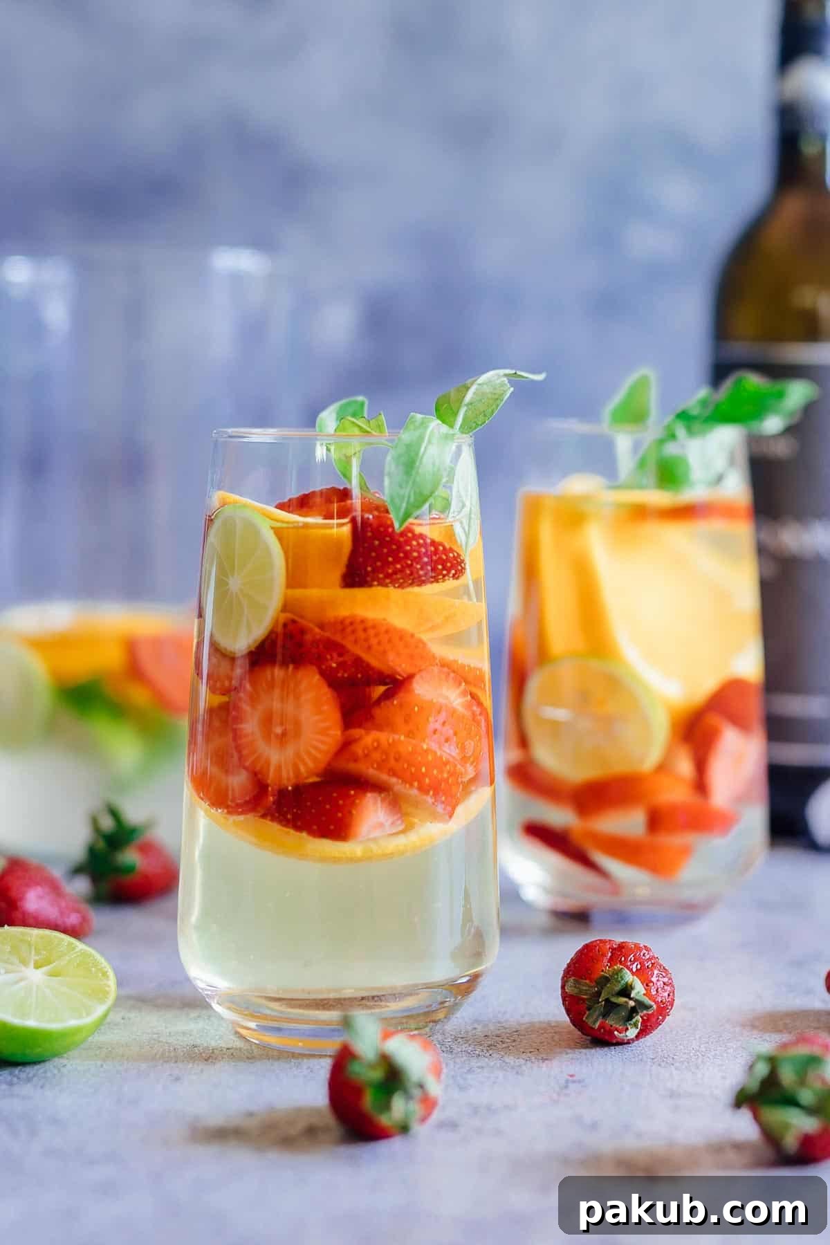 Strawberry Orange White Wine Sangria served in two glasses with limes and basil