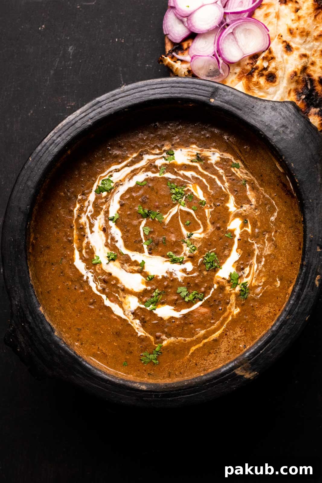 Dal Makhani Mastery Stovetop Pressure Cooker Instant Pot 2 Indian Dal Makhani served in a traditional mud pot, elegantly drizzled with fresh cream on top, inviting you to savor its richness.