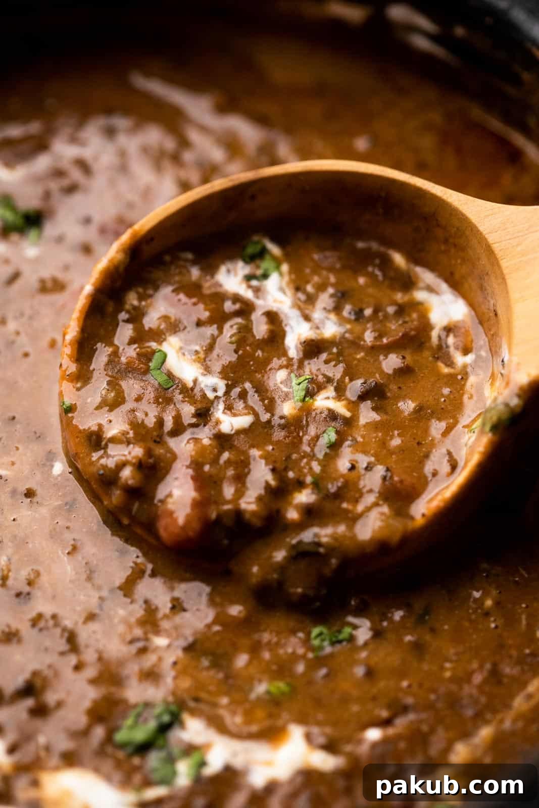 Dal Makhani Mastery Stovetop Pressure Cooker Instant Pot 3 A close-up of a ladleful of Dal Makhani, highlighting its rich, creamy texture and showing the tender black lentils and kidney beans.