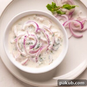 Refreshingly Versatile: The Best Indian Raita Recipes 5 Picture of onion raita served in a white bowl on a white plate