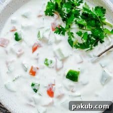 Refreshingly Versatile: The Best Indian Raita Recipes 8 Closeup of Indian raita served in a white bowl topped with coriander or cilantro.
