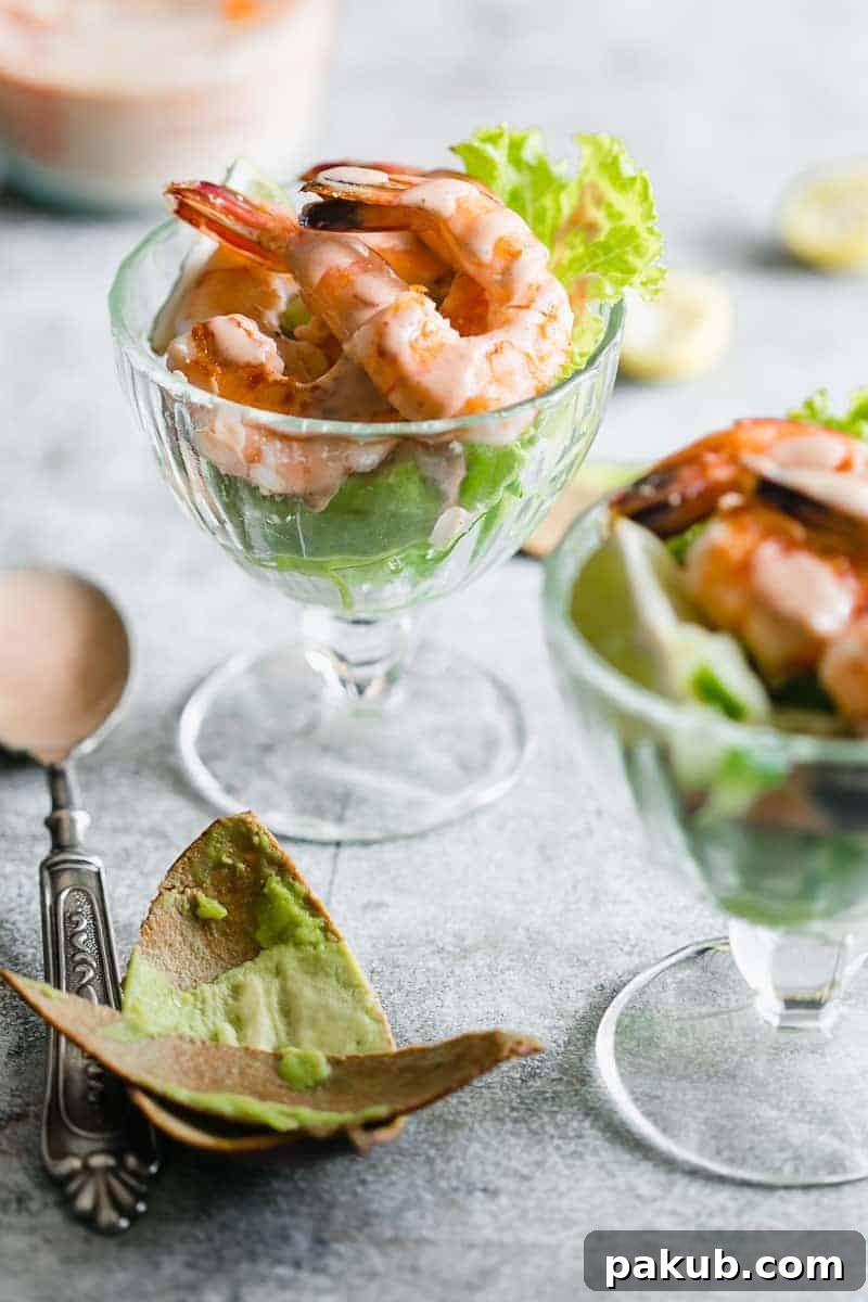 Retro prawn cocktail served in stem glasses with marie rose sauce drizzled over them
