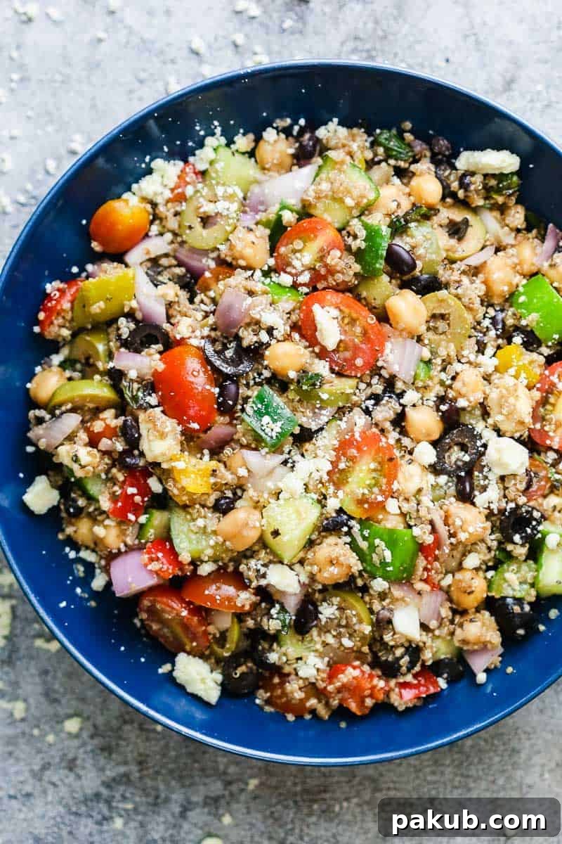 Vibrant and Healthy Mediterranean Quinoa Salad 2 A vibrant Mediterranean quinoa salad served in a blue bowl, generously sprinkled with crumbled feta cheese.