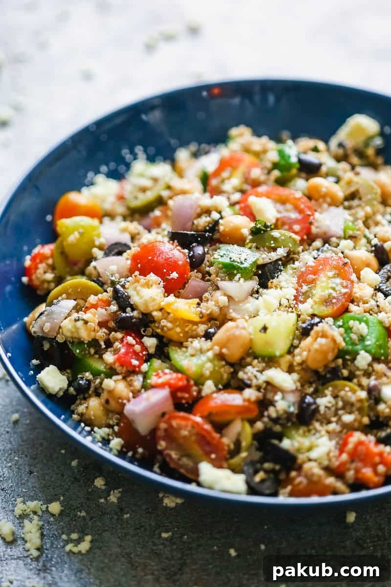 Vibrant and Healthy Mediterranean Quinoa Salad 3 A close-up, different angle of the Mediterranean quinoa salad in a blue bowl, showcasing the fresh ingredients and crumbled feta.