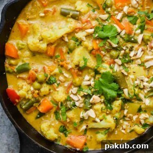 Close-up of a serving of Vegetable Korma Curry, showing its rich texture and fresh ingredients.