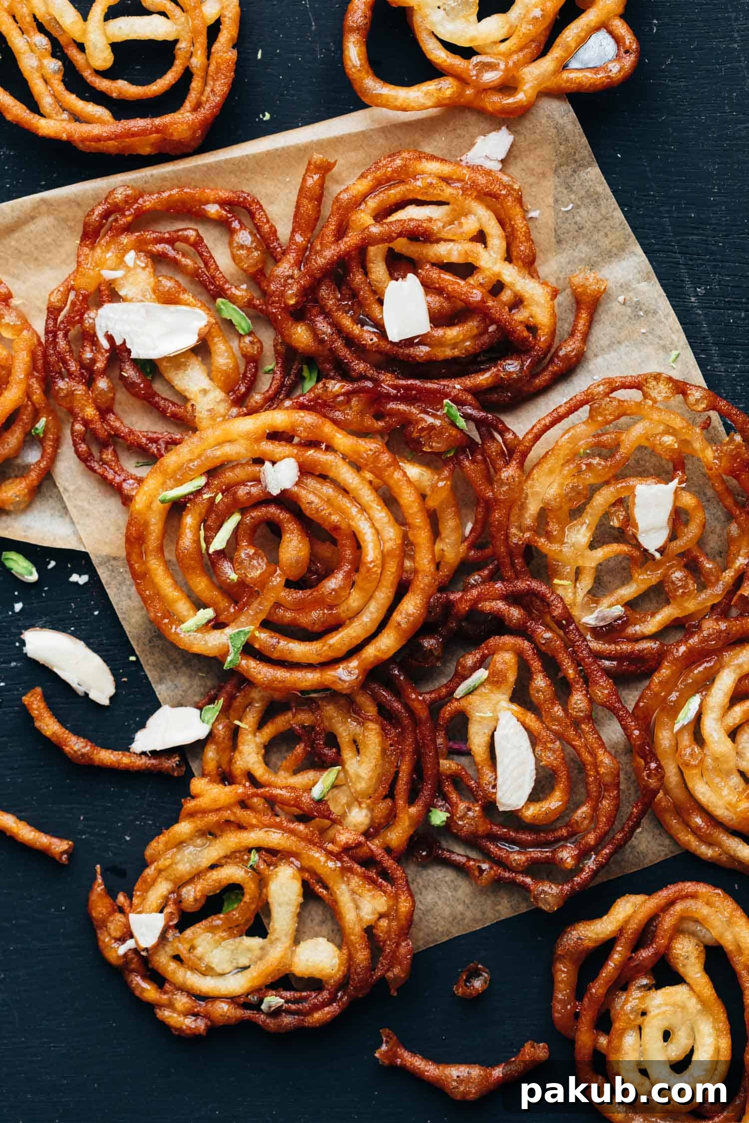 Thin and Crispy Homemade Jalebis 2 Overhead shot of crispy homemade jalebis with almond flakes sprinkled on top