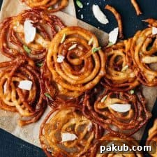 Overhead shot of crispy homemade jalebis with almond flakes sprinkled on top