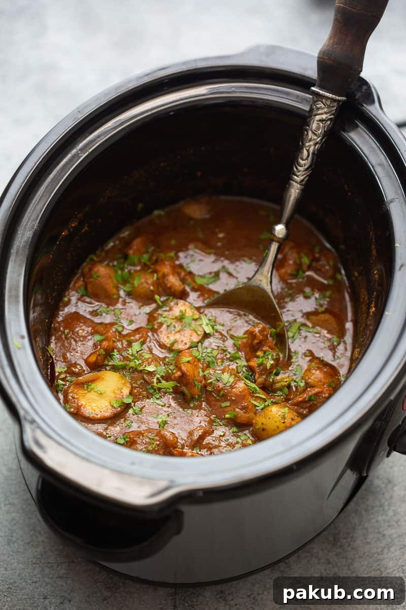 Creamy Coconut Slow Cooker Chicken Curry 4 A large slow cooker filled with the freshly prepared chicken curry, topped with vibrant chopped coriander, ready to be served.