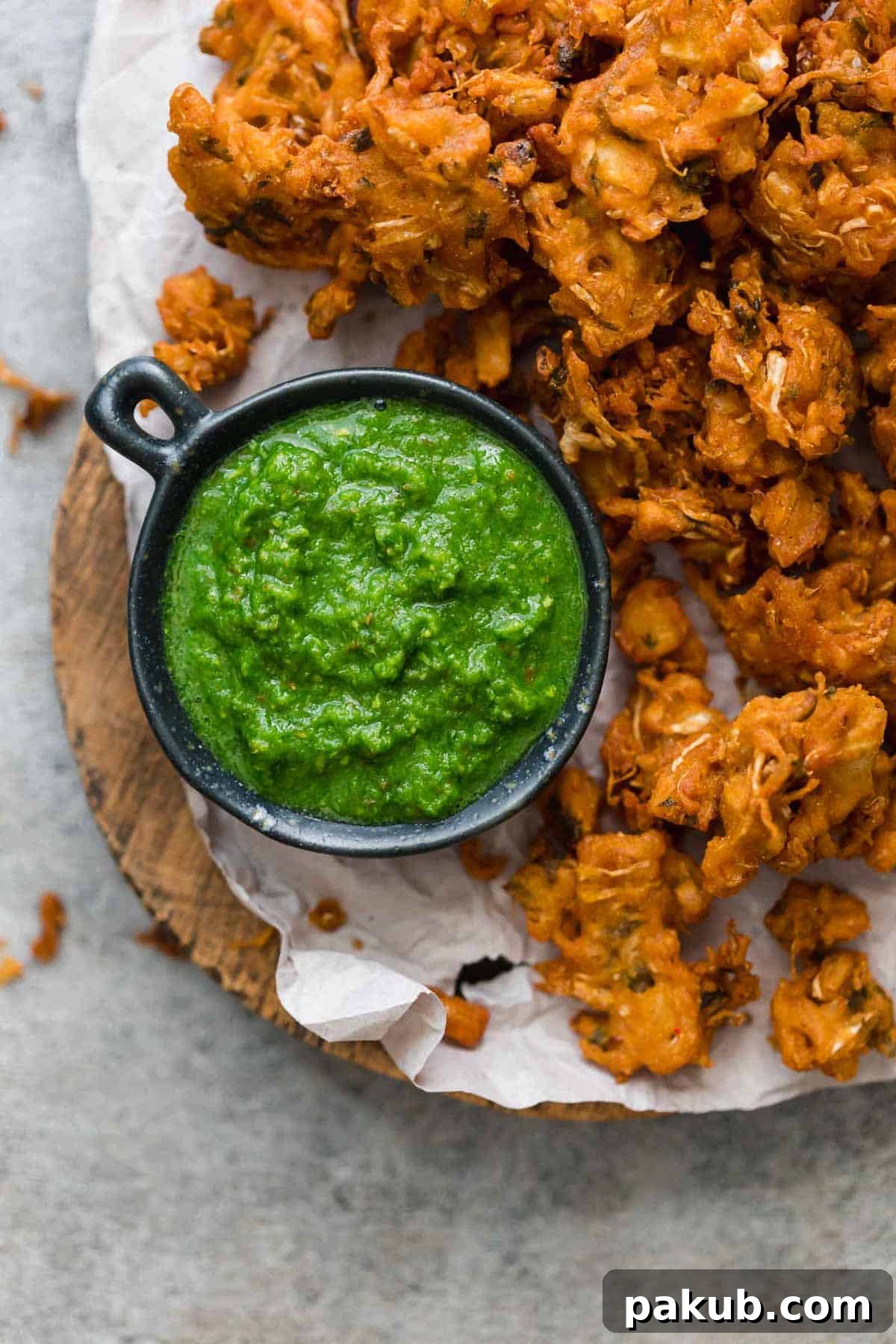 Green Coriander Chutney The Perfect Dip for Anything 2 Vibrant Green Cilantro Chutney served alongside golden-brown pakoras or fritters, ready to be enjoyed.