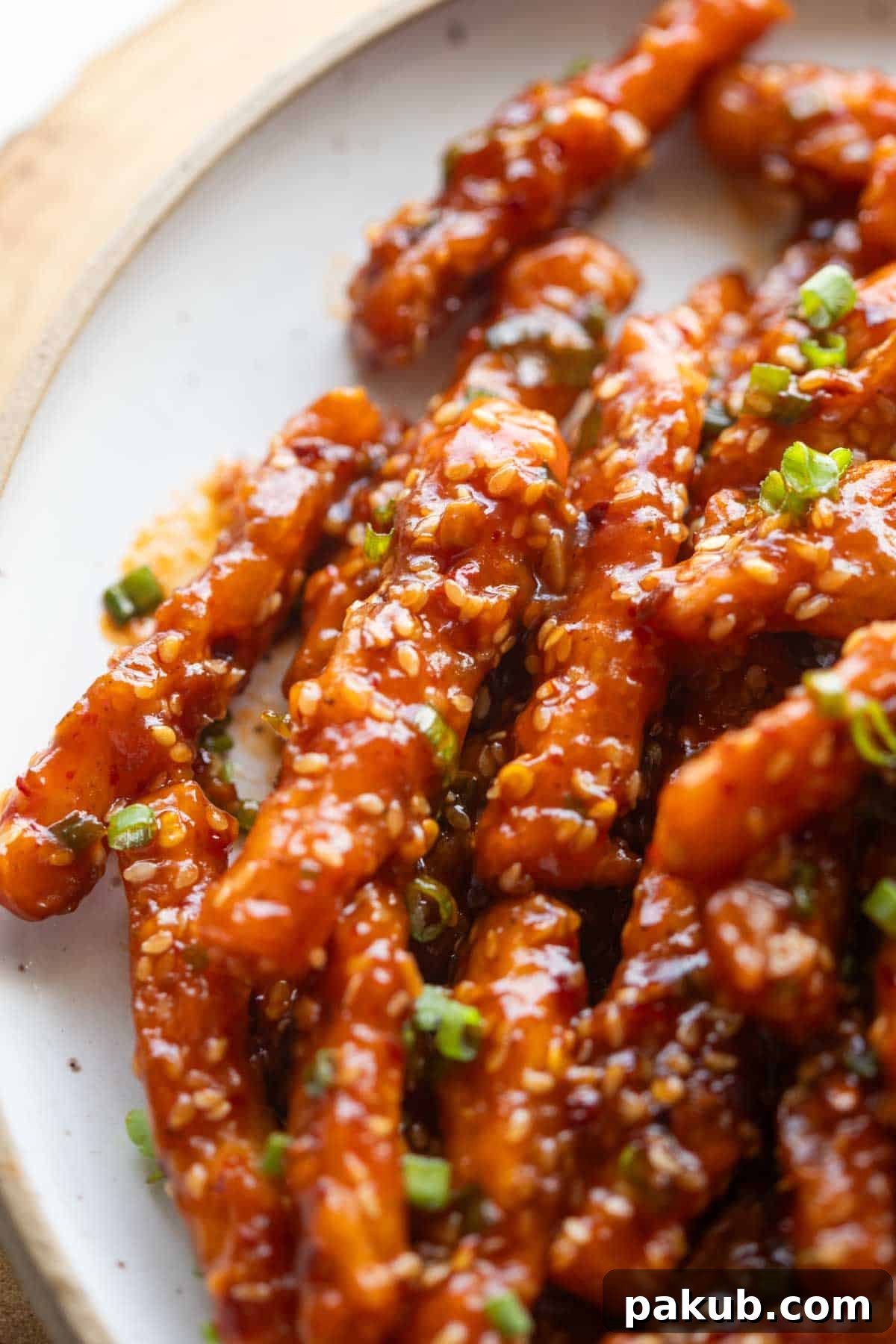 Honey-Chili Glazed Crispy Potatoes 2 Close up image of perfectly crispy honey chilli potatoes tossed in a rich, glossy sauce, showcasing their inviting texture and delicious coating.