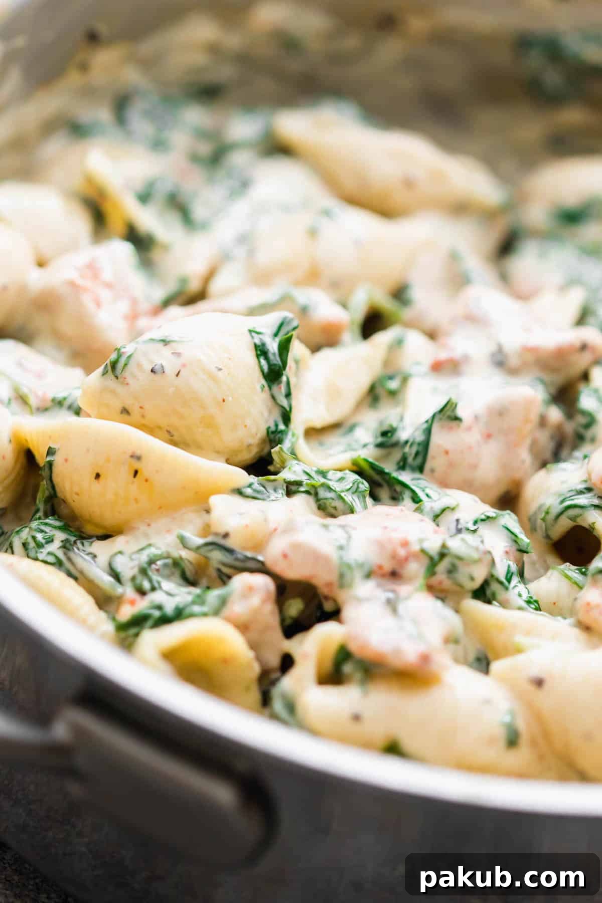 Closeup of creamy chicken florentine pasta in a pan, highlighting the rich, smooth sauce and perfectly incorporated ingredients.