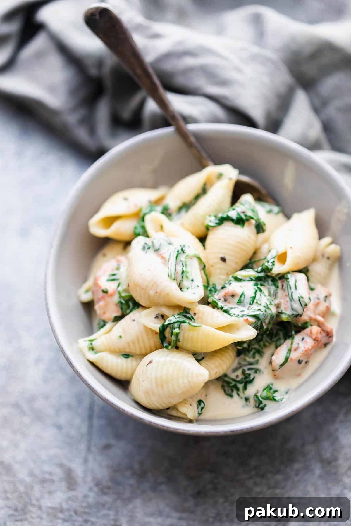 A single serving bowl of creamy chicken florentine pasta, garnished and ready to eat.