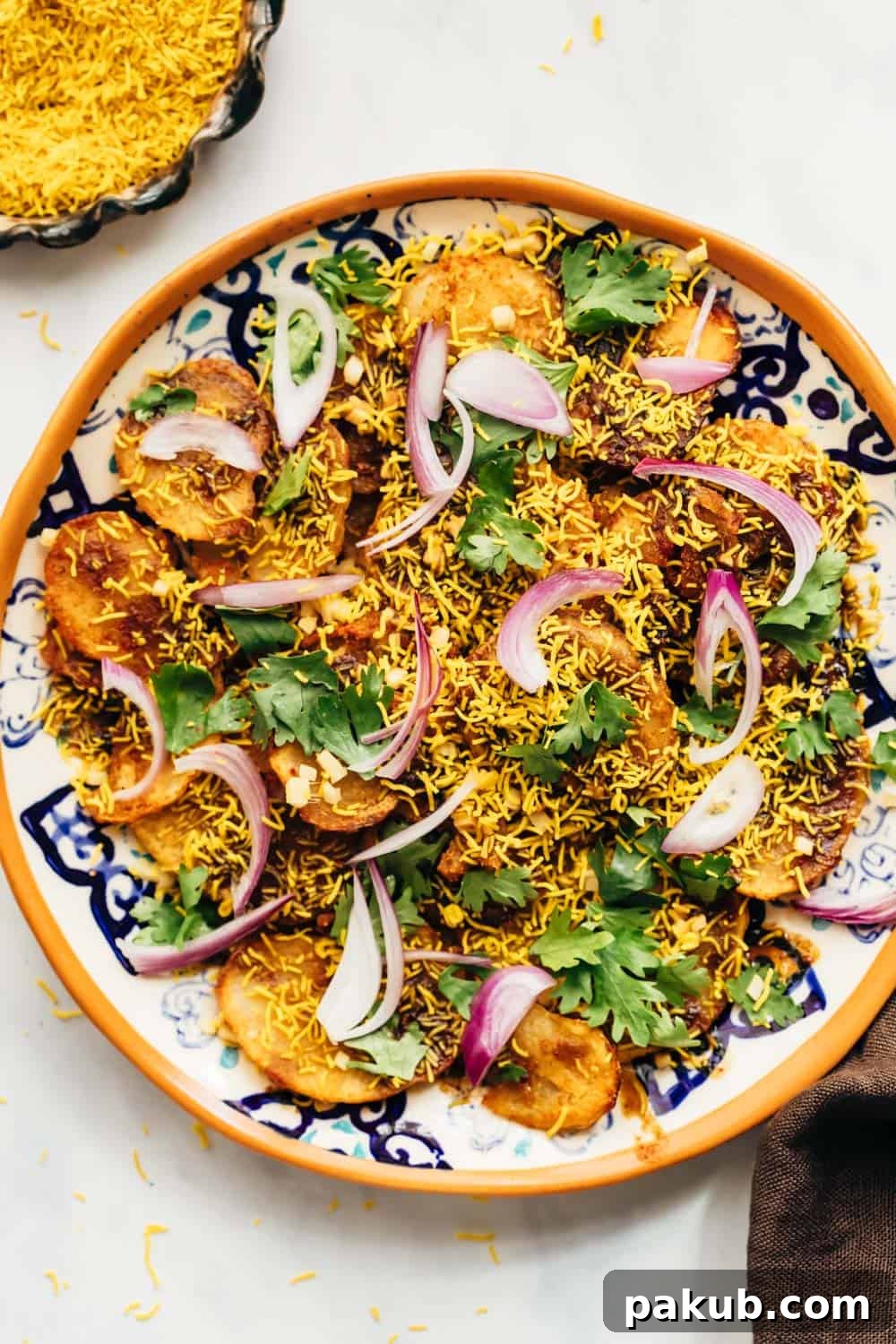 Simple Delhi Aloo Chaat 4 Closeup of easy Aloo Chaat - Delhi style served on a plate with sev and lime on the side, showing the delectable toppings and spices