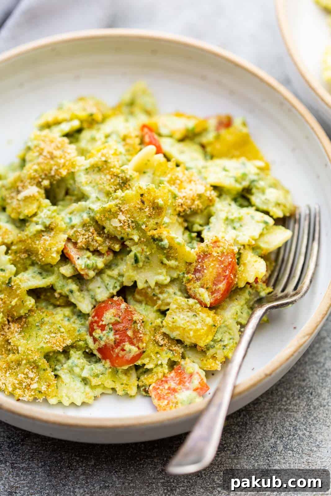 Closeup of pasta in jalapeno pesto served in a pasta bowl with a fork