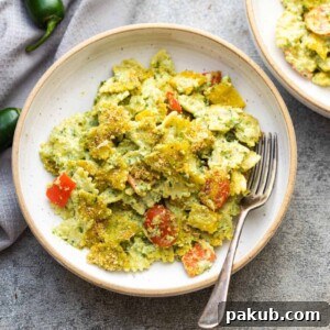 pasta in jalapeno pesto served in a white pasta bowl with a fork