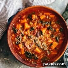 Winter Vegetarian Minestrone Soup served in a bowl topped with parmesan and olive oil