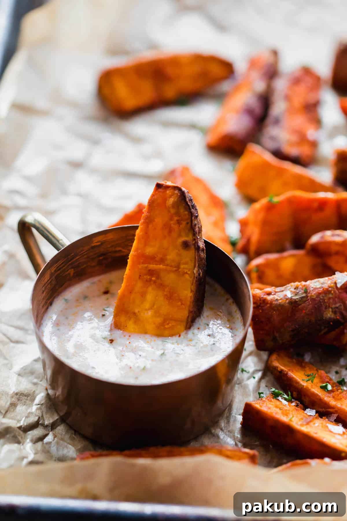 Fiery Zest Sweet Potato Wedges 4 Close-up of Chilli Lime Sweet Potato Wedges being dunked into a creamy dipping sauce.