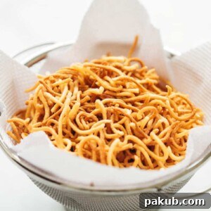 Crispy Fried Noodles on tissue paper, showcasing their golden crunch and perfect texture