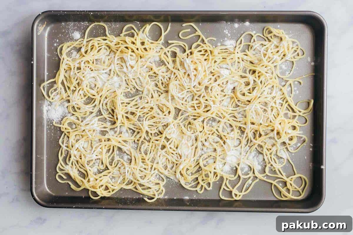 Noodles generously dusted with corn flour, ready for deep frying to become crispy fried noodles