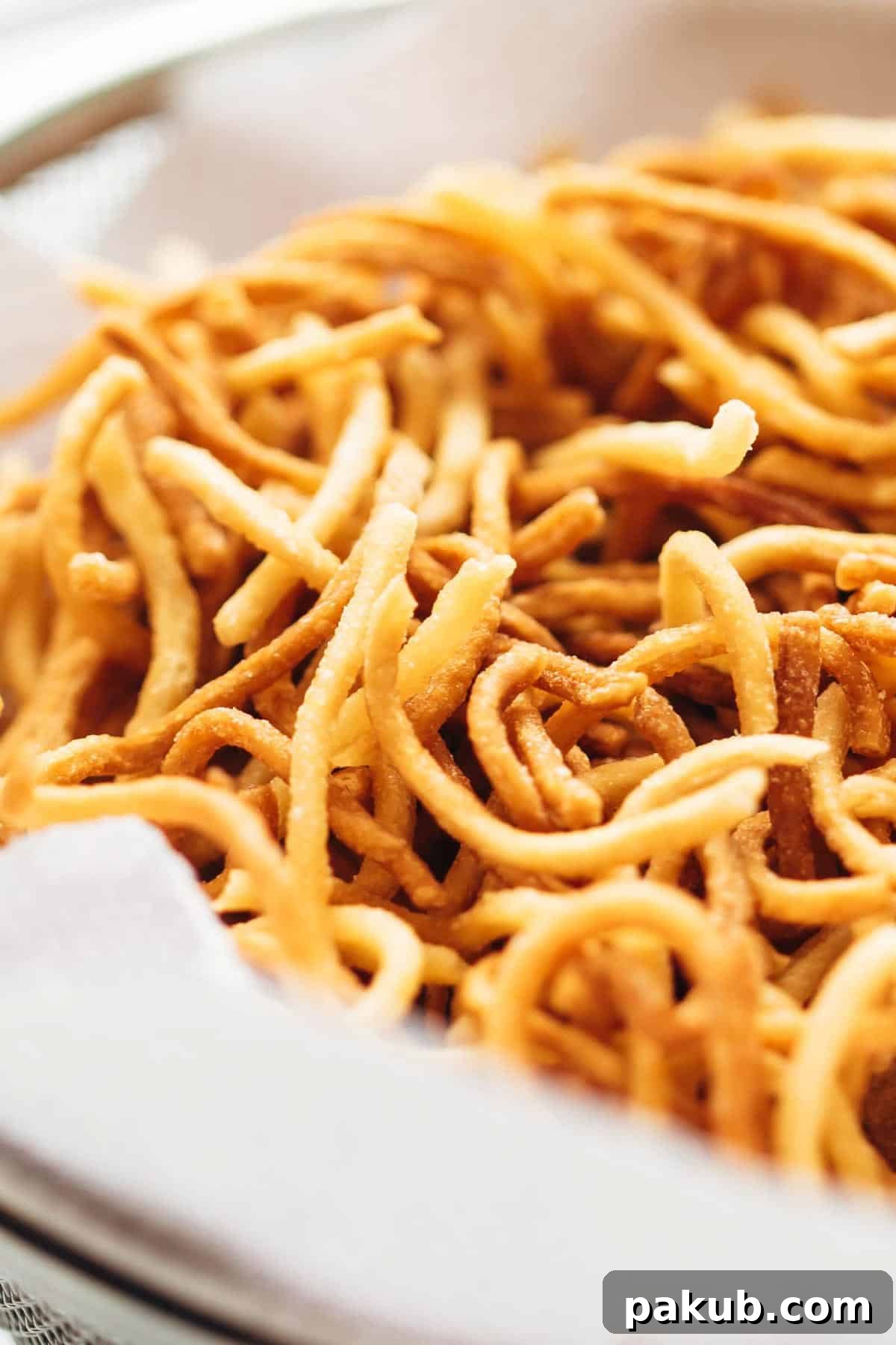 Close-up of perfectly crispy fried noodles, highlighting their golden color and separated strands