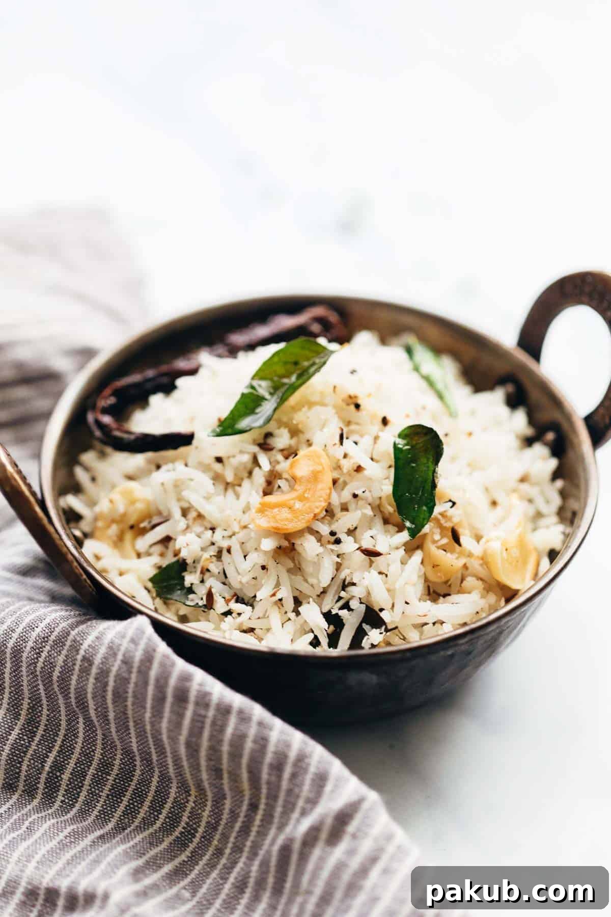 Quick & Easy 15-Minute Coconut Rice Stir-Fry 2 Coconut rice served in a kadhai topped with roasted cashews and curry leaves