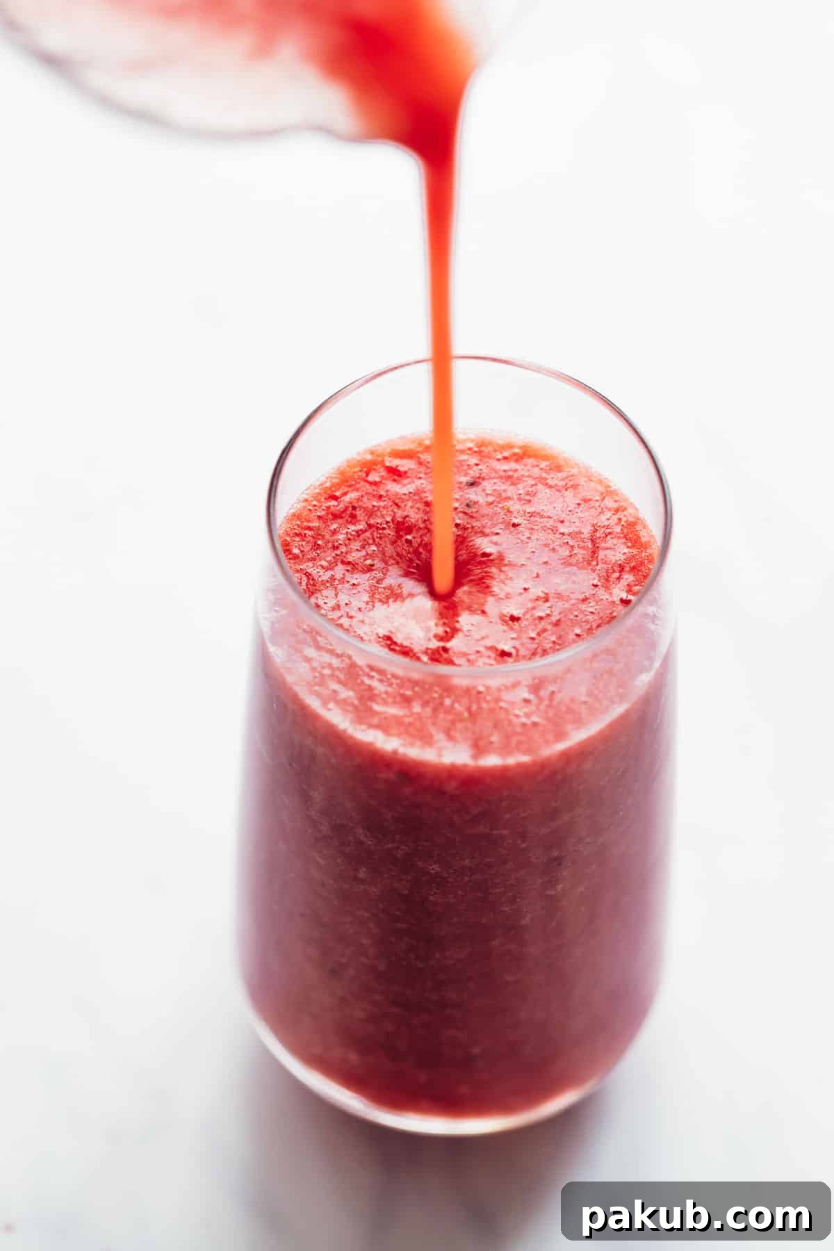 Velvet Watermelon Lime Chill 4 Smooth, vibrant pink watermelon lime smoothie being poured from a blender into a tall glass, ready for immediate enjoyment.