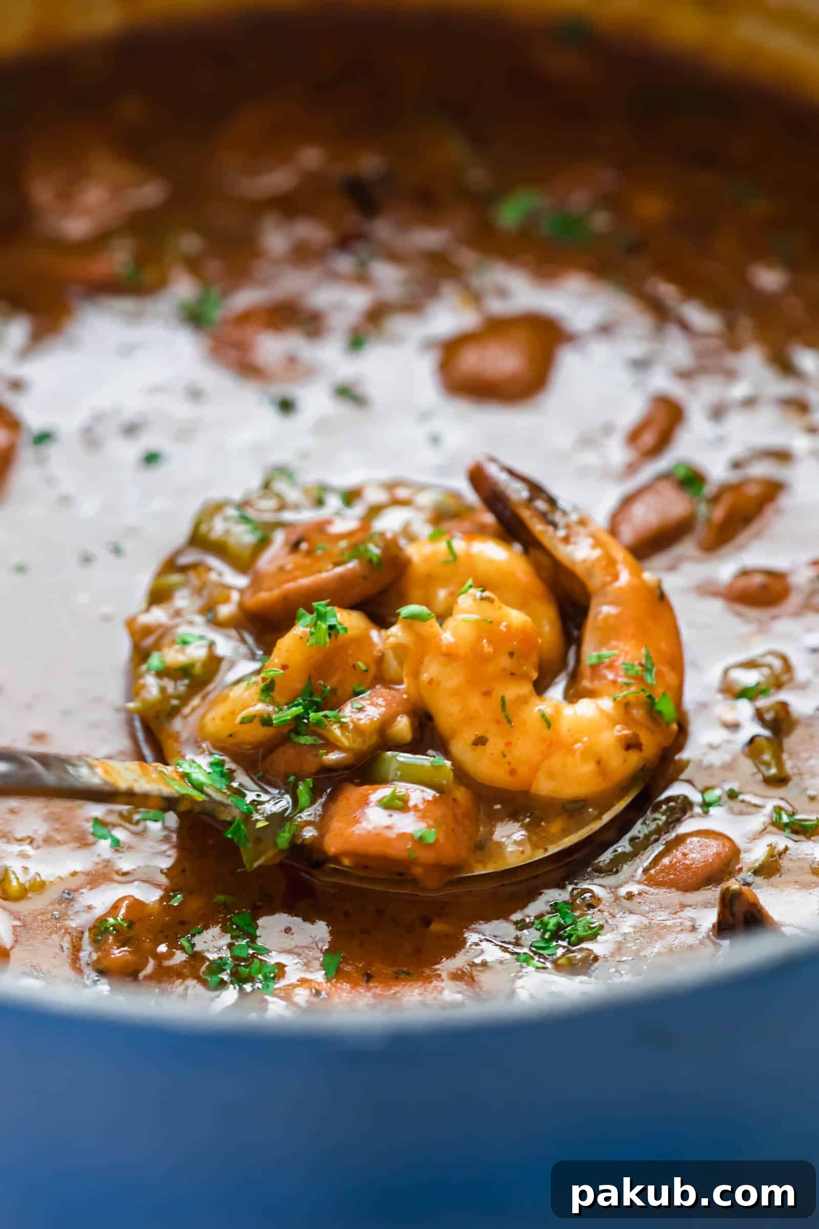 Close up view of New Orleans Shrimp and Sausage Gumbo simmering in a pot, showcasing its rich, thick consistency and savory ingredients.