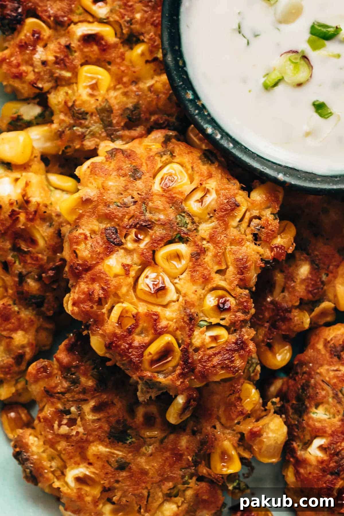 Fiesta-Ready Mexican Corn Fritters in 15 Minutes 2 Mexican corn fritters served with a creamy dip on the side