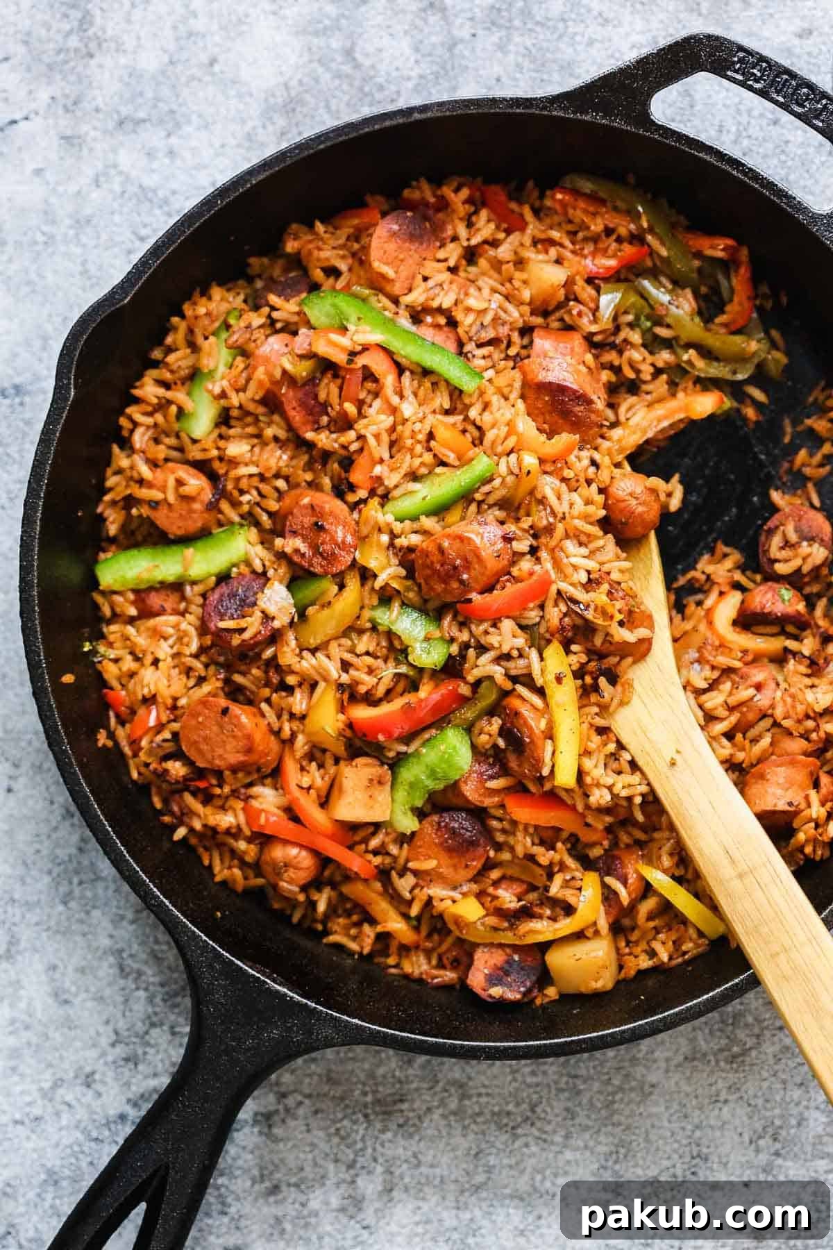 One Pot Mexican Rice and Sausages served in a cast iron pan, steaming hot and ready to eat