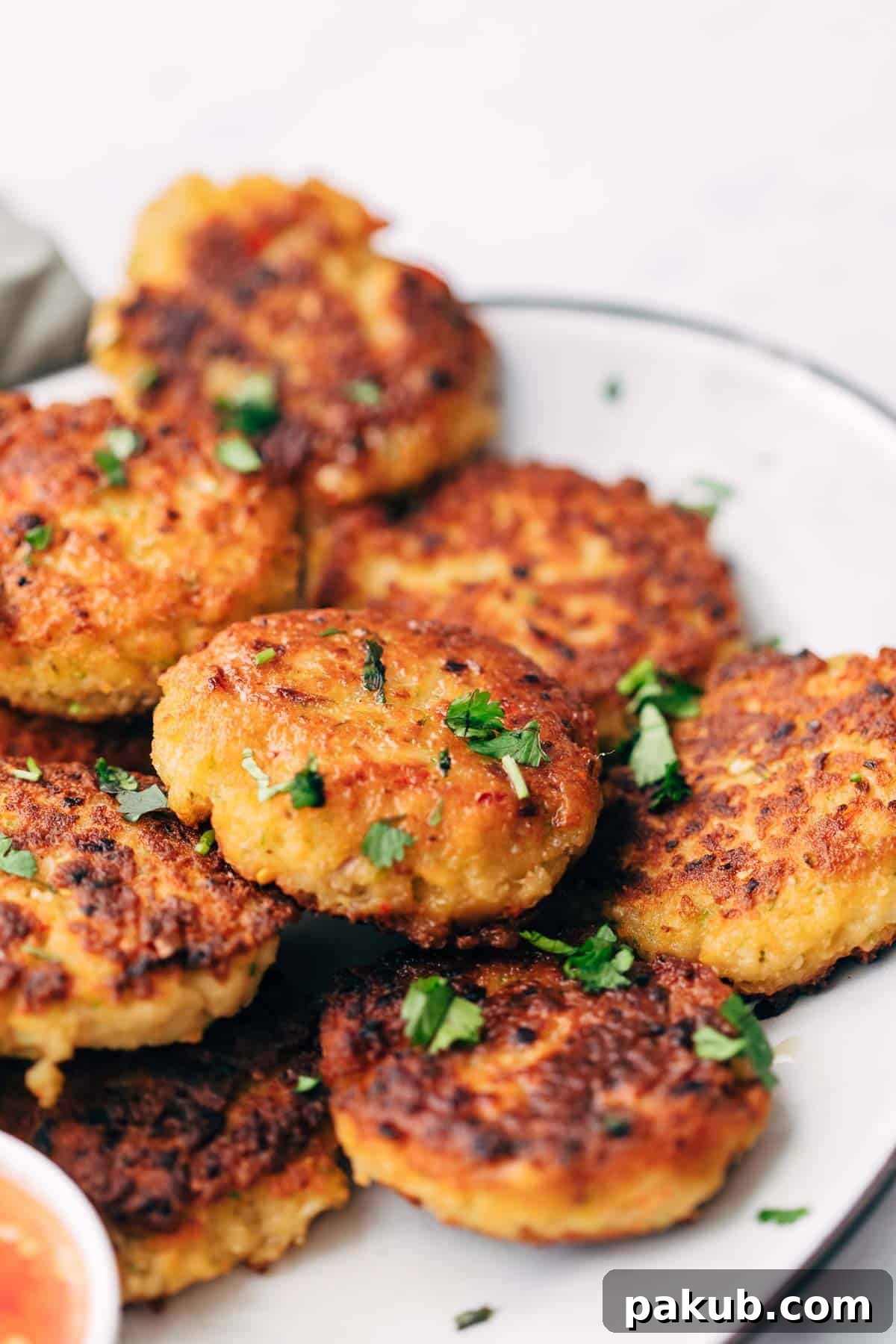 Platter of golden, crispy Easy Thai Shrimp Cakes served with a side of vibrant Thai sweet chilli sauce