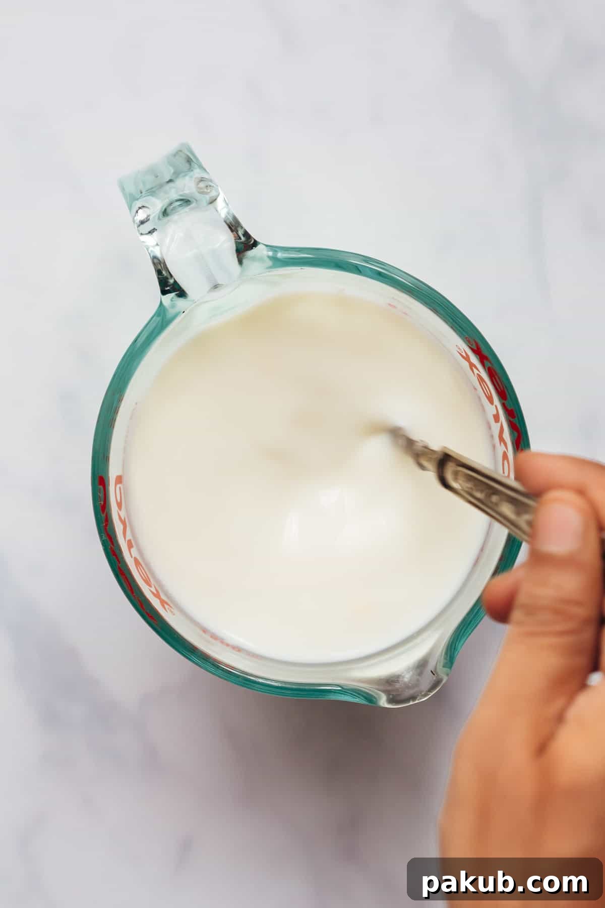 Stirring the ingredients to make buttermilk at home.