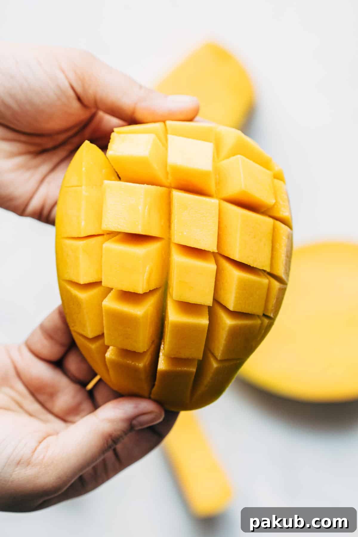Easy Step-by-Step Guide to Cutting a Mango 2 A perfectly peeled mango, meticulously cut into uniform dices with precise horizontal and vertical cuts, ready for serving or incorporating into recipes.