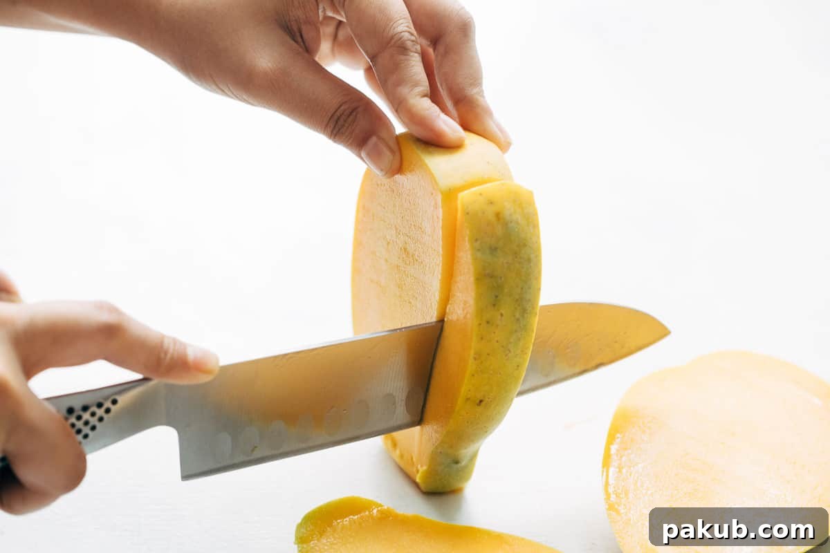 Easy Step-by-Step Guide to Cutting a Mango 6 Wedges of mango flesh being carefully cut away from the sides of the central pit, ensuring no edible fruit is wasted.