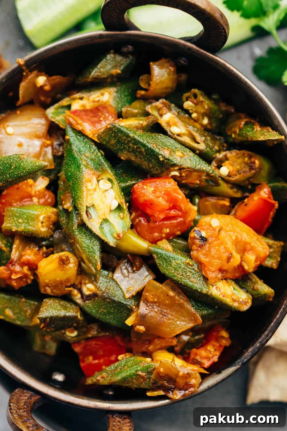 Effortless Spiced Okra Stir Fry 3 Close-up shot of Bhindi Masala showcasing tender, spice-coated okra pieces mingling with onions and tomatoes in a wok, highlighting the vibrant colors and appealing texture of the dish.