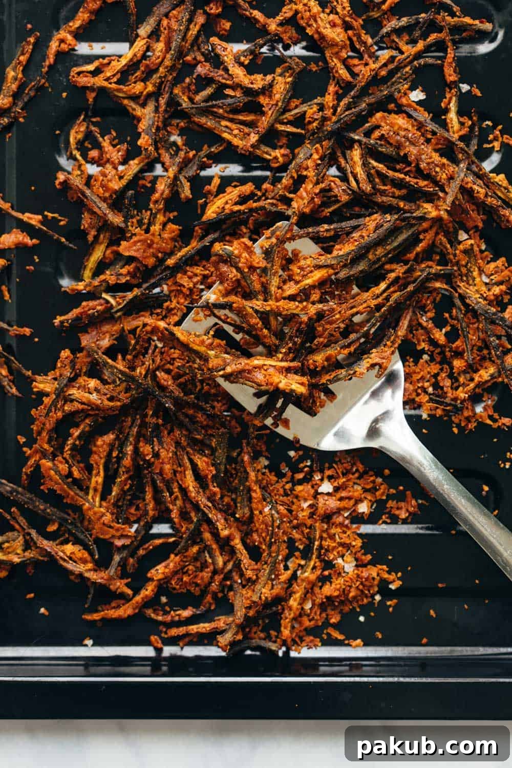 Golden Baked Okra Crisps 3 Freshly baked kurkuri bhindi evenly spread on a baking tray, showcasing its appealing golden brown and crisp texture.