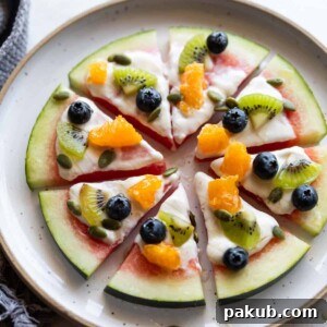 watermelon pizza slices topped with fresh fruits on a white plate
