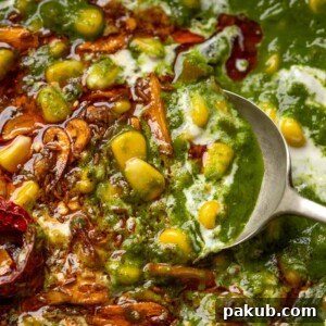 Spoon going into corn palak to show the texture and garlic tadka