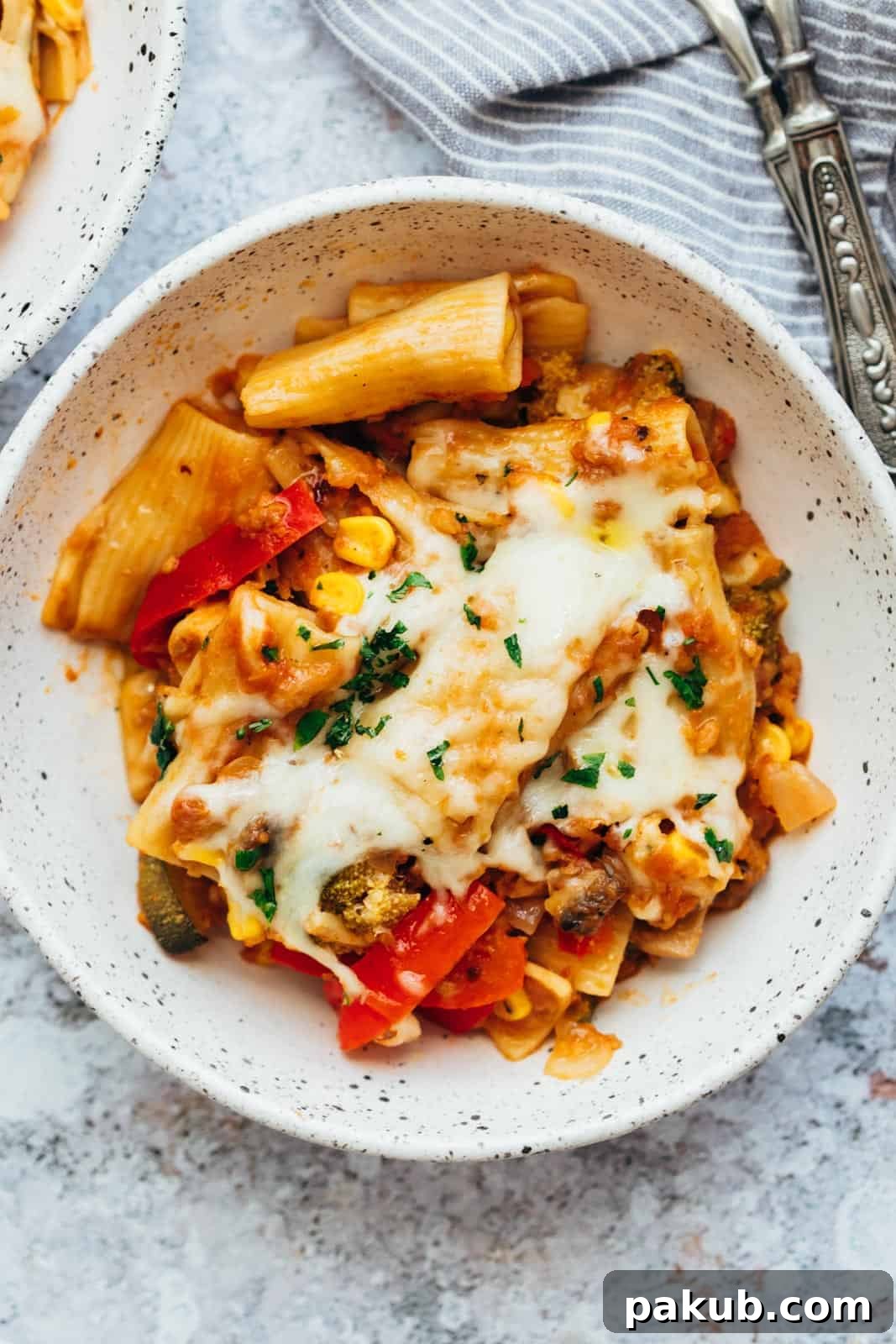 A serving of one-pot vegetable pasta in a white bowl, garnished with fresh herbs, ready to be enjoyed.