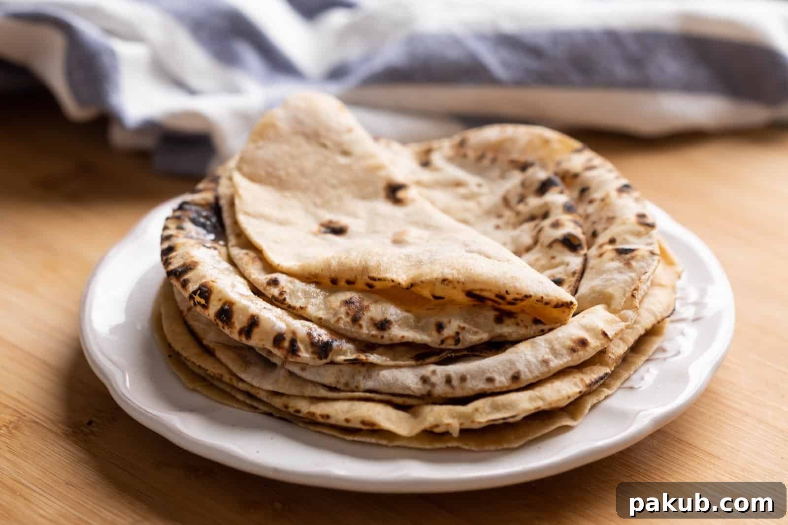 Mastering Soft Rotis at Home 3 Stacked soft rotis, glistening with fresh ghee, showcasing their fluffy, irresistible texture.