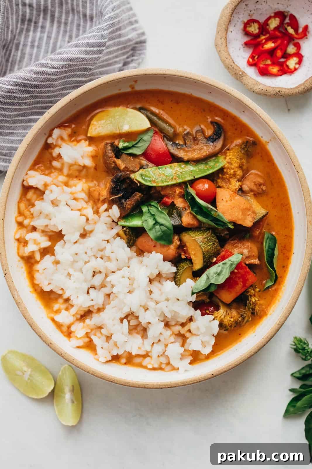 Flavorful Instant Pot Thai Chicken Curry 2 Instant Pot Thai chicken curry served in a bowl with fluffy rice, garnished with fresh Thai red chilies and bright lemon wedges.