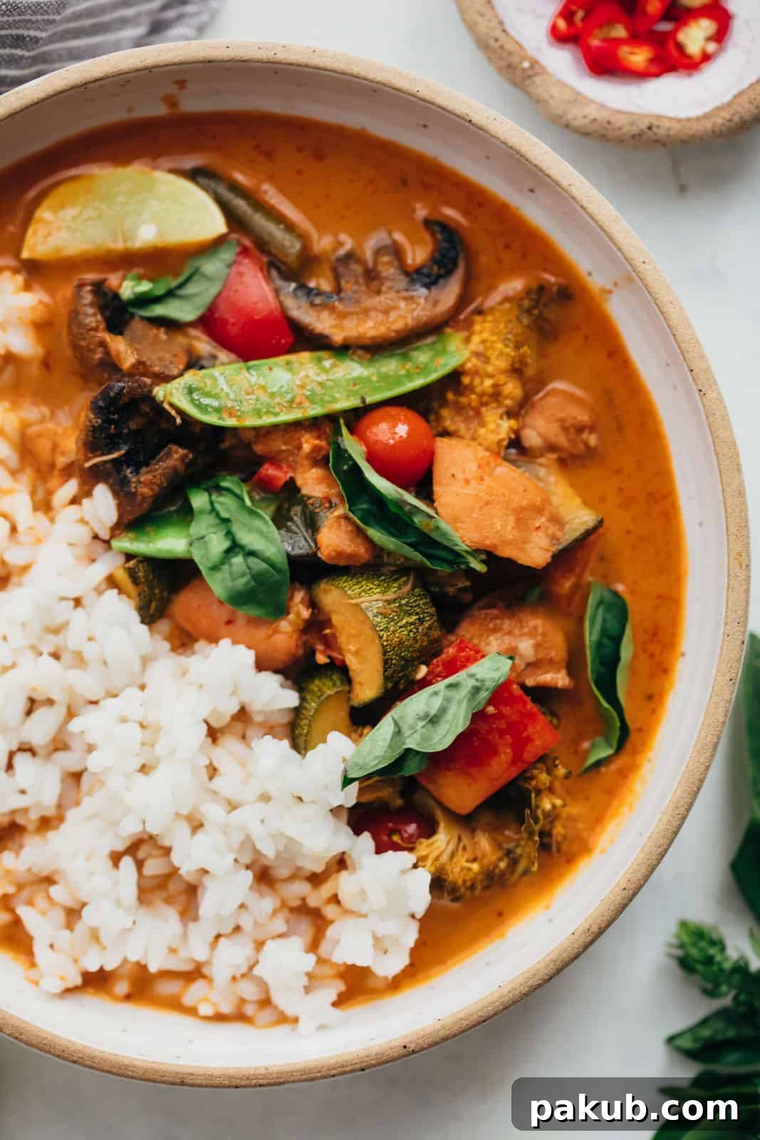 Flavorful Instant Pot Thai Chicken Curry 4 Close-up view of Instant Pot Thai chicken curry, showcasing the rich sauce and tender chicken, served with rice, chilies, and lime.
