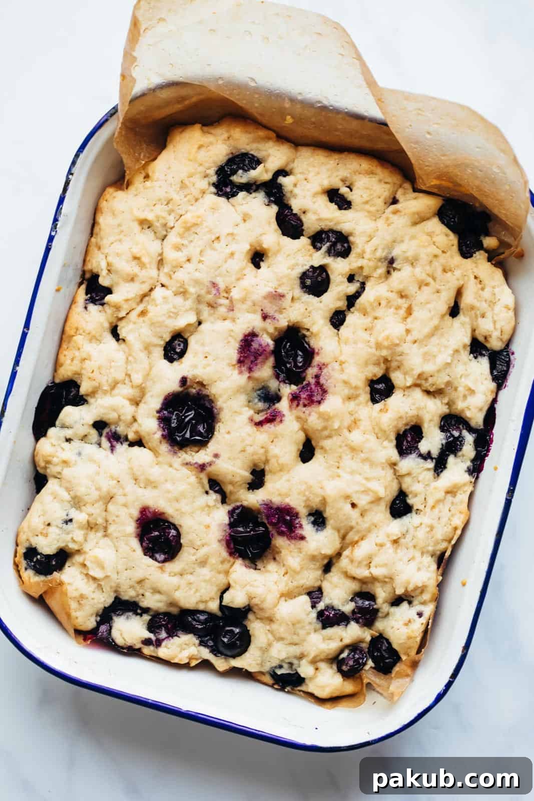 Lemon Blueberry Cake Bars in a baking tin, freshly baked and ready to slice