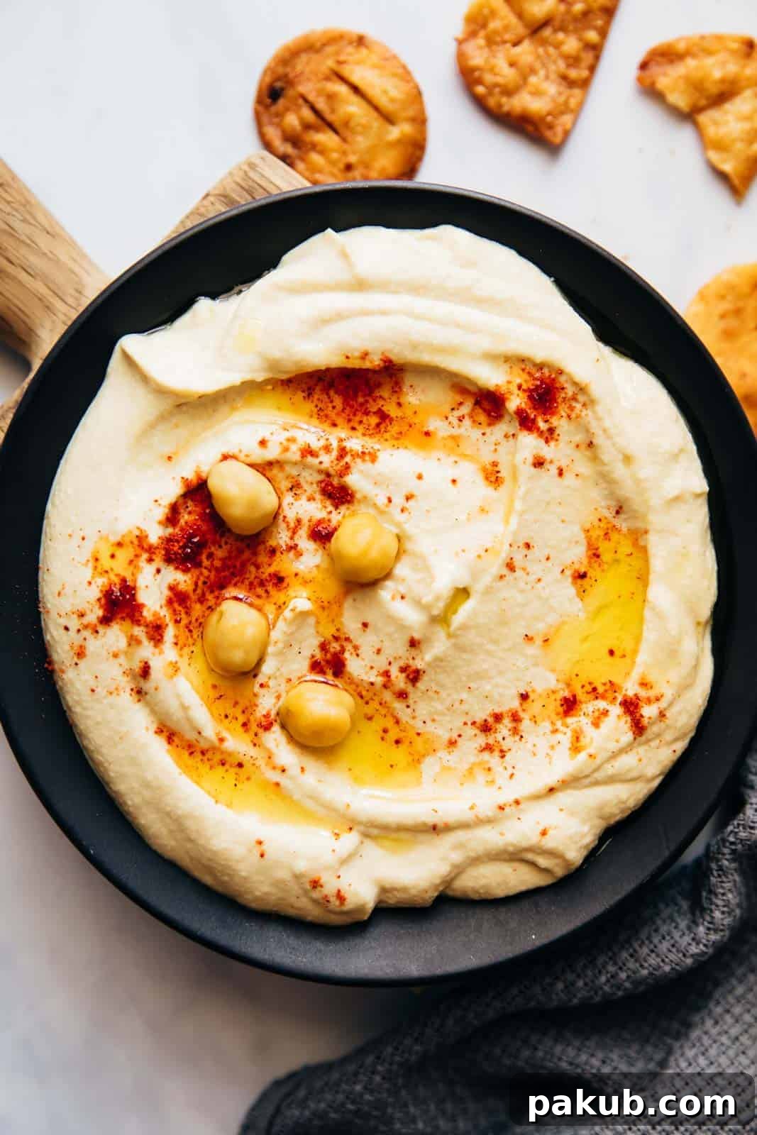 Whip Up Perfectly Light and Fluffy Homemade Hummus 2 Hummus served on a plate with fried pita, olive oil and chickpeas