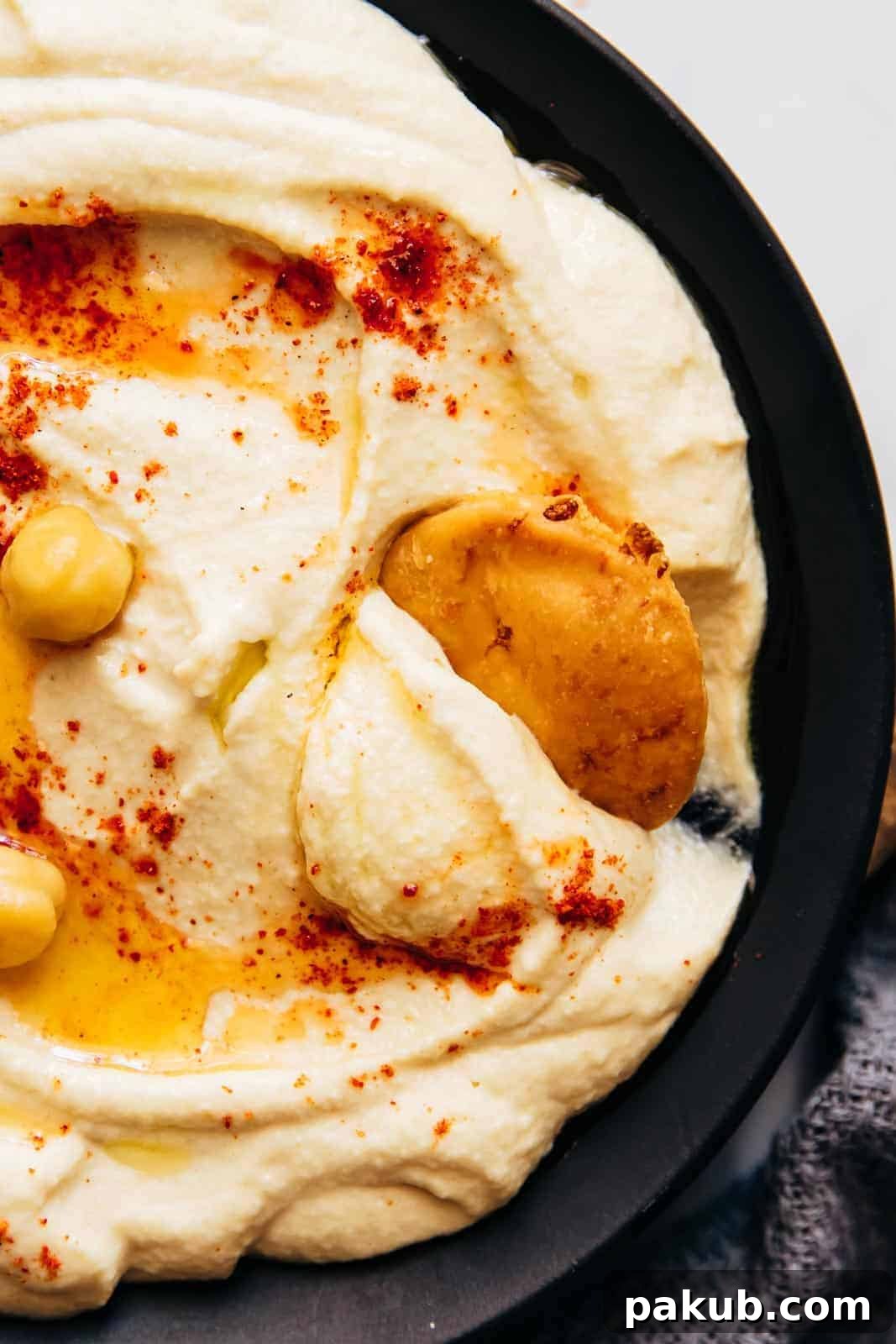 Whip Up Perfectly Light and Fluffy Homemade Hummus 7 Closeup of pita scooping up hummus to show smooth texture