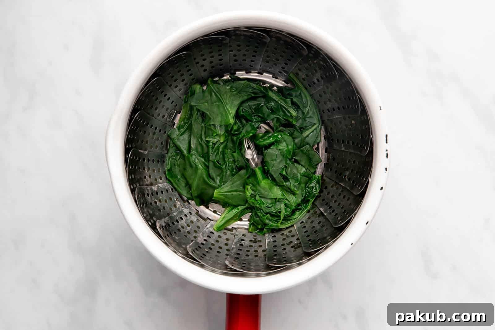 Spinach Magic Three Ways From Pan to Freezer 5 Fresh spinach leaves gently wilting in a steamer basket over boiling water
