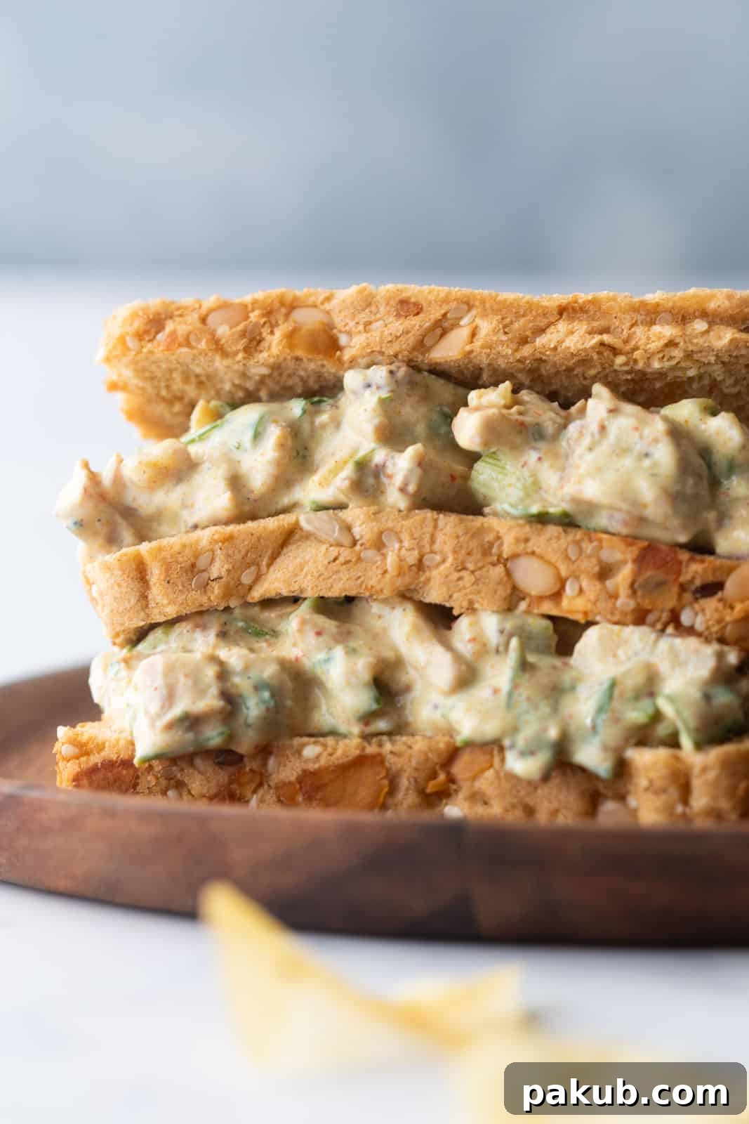 Delightfully Easy and Healthy Curry Chicken Salad Sandwich 2 Closeup of curry chicken salad sandwich on a plate, showcasing its rich texture and vibrant colors