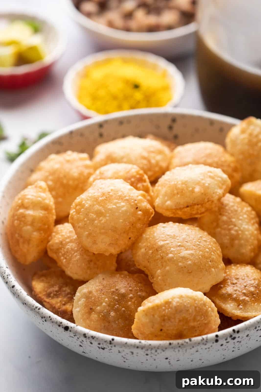 Effortless Homemade Pani Puri 4 Puris served in a bowl with the pani and filling in the background, inviting guests to assemble their own pani puri