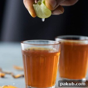 Fresh Lemon being squeezed into a bright golden cup of Turmeric Tea, signifying vitality and health.